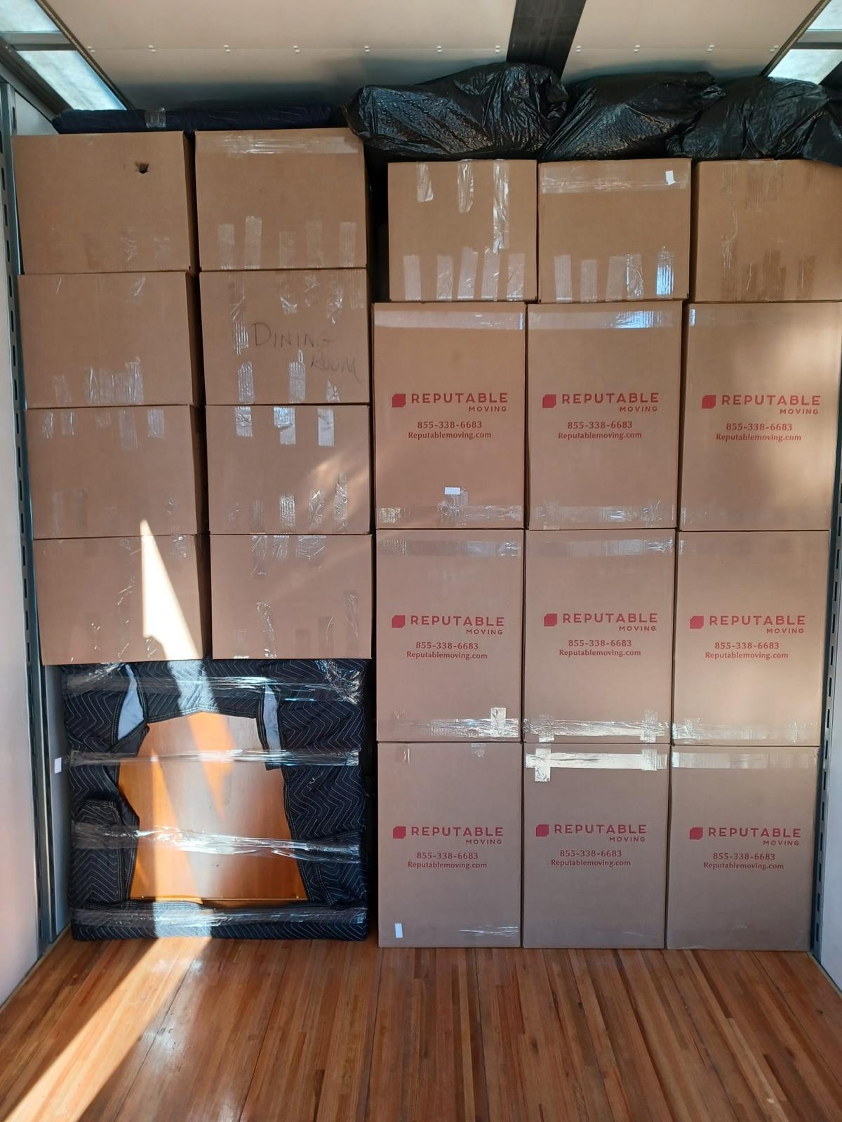 Reputable truck interior packed tight with branded boxes stacked floor to ceiling