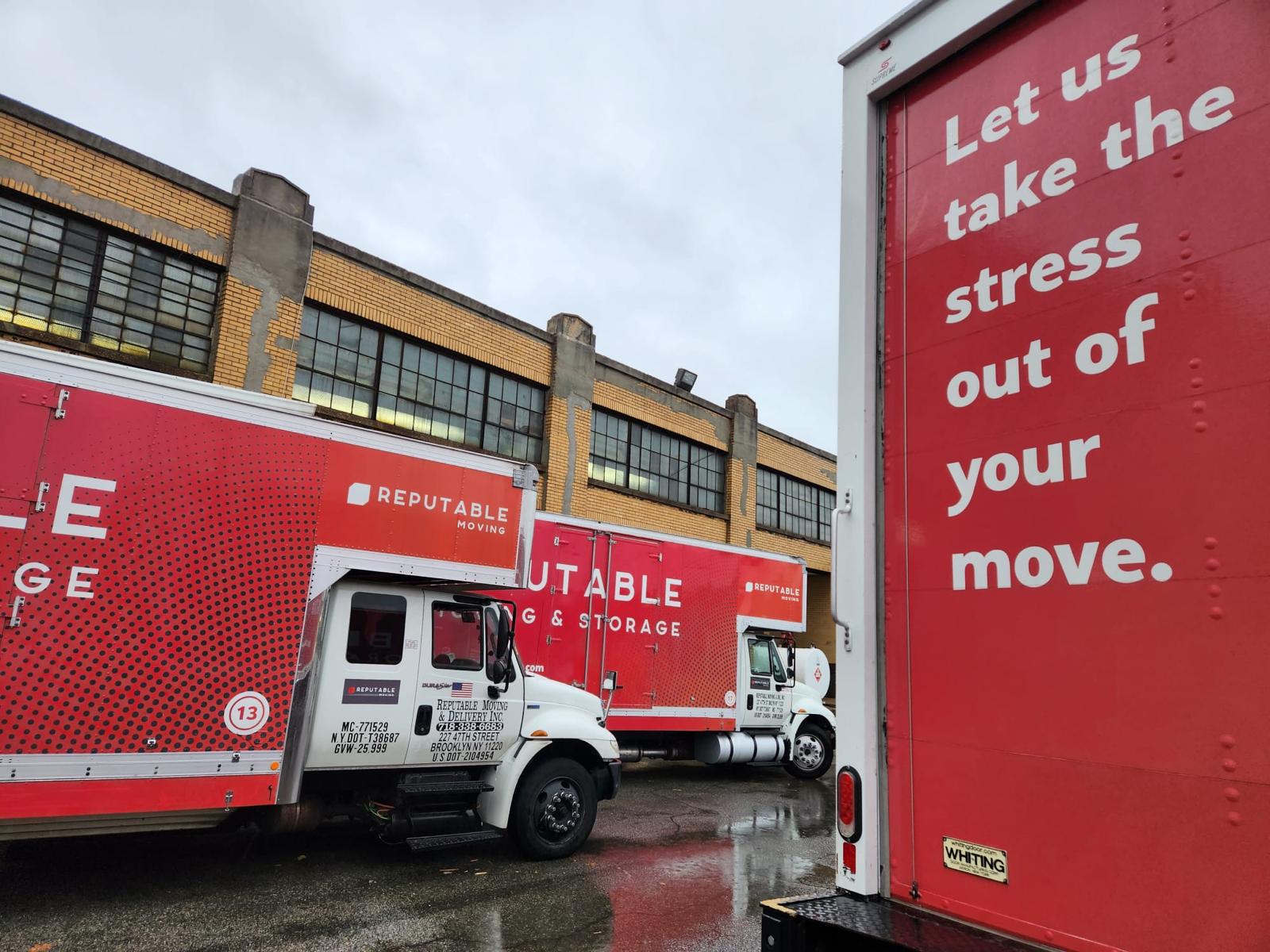 Two red Reputable trucks at a brick industrial loading bay with a pallet jack